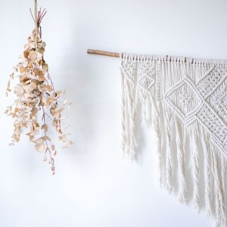 Handgeknüpfter Makramee-Wandbehang an weißer Wand