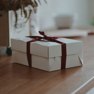 Geschenkbox mit gebundener Schleife auf Holztisch
